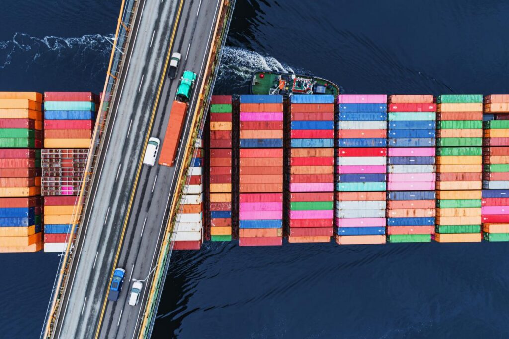 A container ship passes beneath a suspension bridge as it departs for Europe.