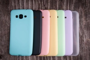 colorful plastic materials on back covers for mobile phones over rustic wooden background