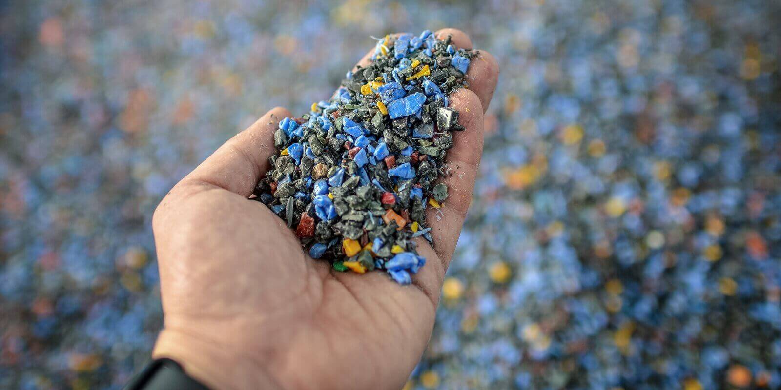 hand holding recycled plastic chips as raw material in production