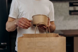 Person Holding Biodegradable Polymer Bag and Container