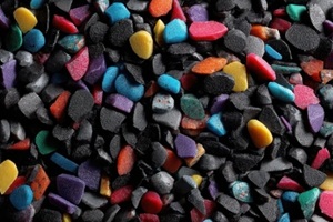 pile of black plastic regrind mixed with colorful recycled bits