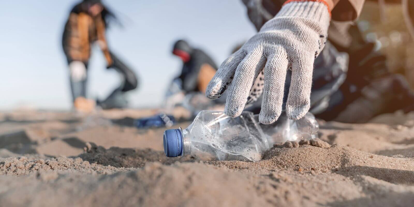 volunteer man collecting trash on the beach