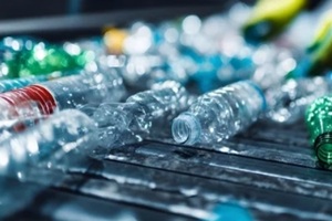 worker sorting plastic bottles on a conveyor belt in a recycling plant for environmental sustainability 