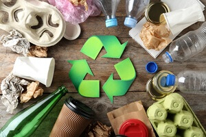 recycling symbol and different garbage on wooden background