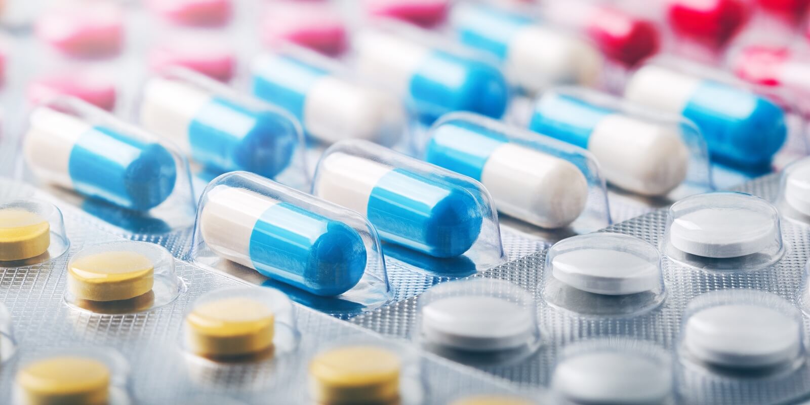 heap of medical pills in white, blue and other colors