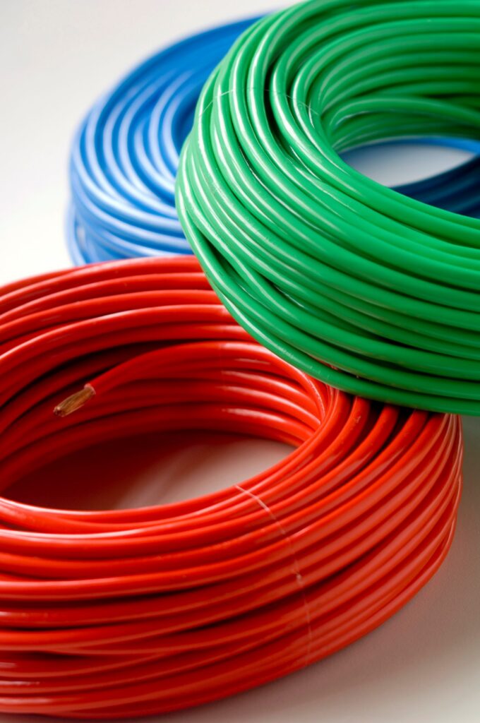 Multi colored electrical cable coils on a white background.