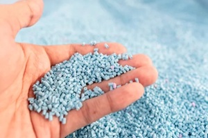 large pile of blue plastic granules in temporary storage of production line at recycle factory