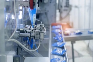 blue bags moving along automated packing conveyor, milk food industry