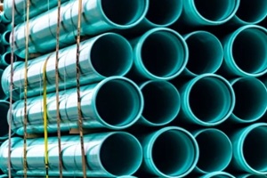 green industrial piping in transit on a semi